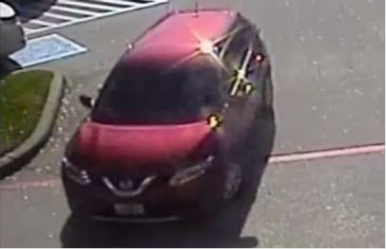 Photo of red suspect vehicle (mini van or crossover in type) in parking lot. 